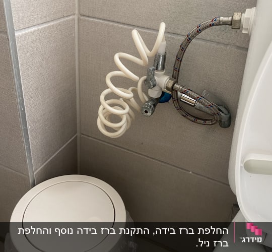 צינור מים גמיש מחובר לברז ליד אסלה
